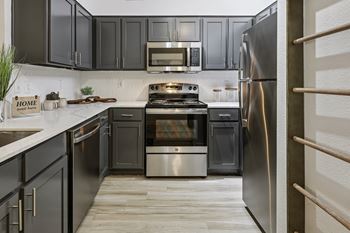 A kitchen with a stove, oven, and refrigerator.